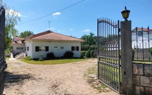 a gate in front of a white house at Quinta dos Choupos in Coimbra