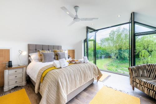 a bedroom with a bed and a large window at 4 Bed in Steeple Bumpstead oc-hatch in Steeple Bumpstead