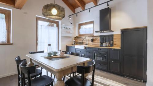 a kitchen with a wooden table and black chairs at Sesto Senso in Ponte di Legno