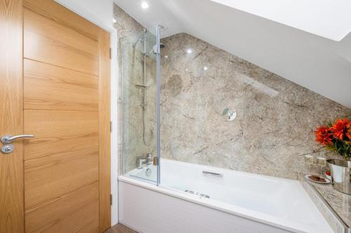 a bathroom with a shower and a bath tub at 4 Bed in Steeple Bumpstead oc-hatch in Steeple Bumpstead