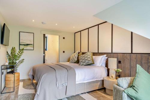 a bedroom with a large bed and a chair at 3 Bed in Looe oc-a29455 in Looe