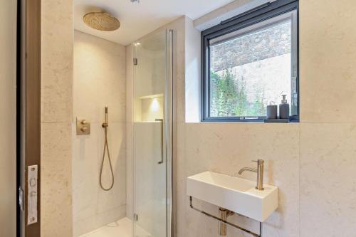 a bathroom with a sink and a shower and a window at 3 Bed in Looe oc-a29455 in Looe