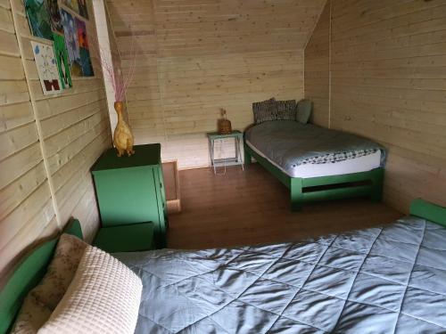 a room with two beds in a wooden cabin at ojcowska stodoła in Wola Kalinowska