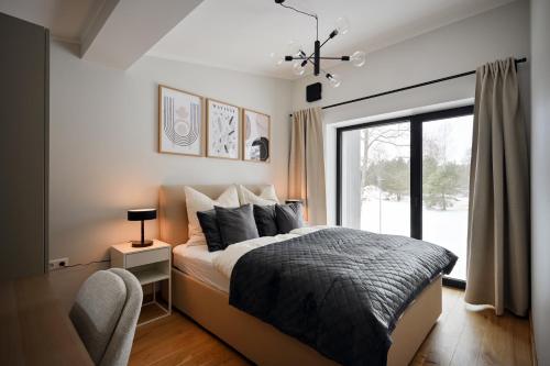 a bedroom with a bed and a large window at Timeout Albatross Resort - Sea, Relax & Design in Ķesterciems