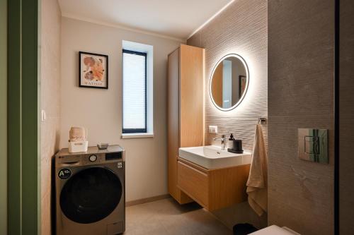 a bathroom with a washing machine and a sink at Timeout Albatross Resort - Sea, Relax & Design in Ķesterciems