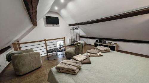 a bedroom with a large bed and two chairs at La Petite Auberge de Graux in Mettet