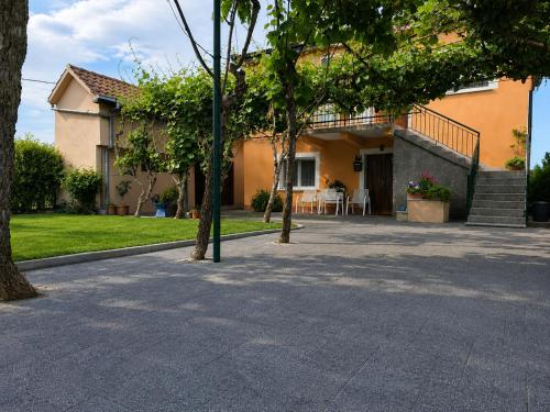 a house with trees in front of a driveway at Apartman ODISEJ in Čapljina