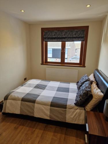 a bedroom with a bed with a checkered blanket at Self-catering extended family home in Edinburgh