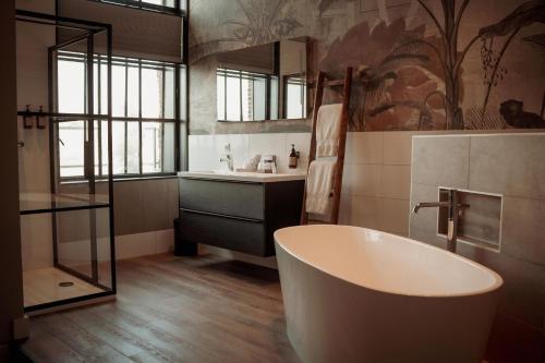 a bathroom with a bath tub and a sink at Boutique Hotel De Oude Veste in Hellevoetsluis