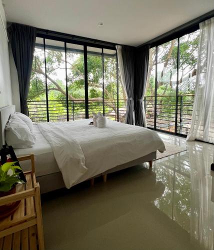 a bedroom with a bed and a large window at Ark Pai in Pai
