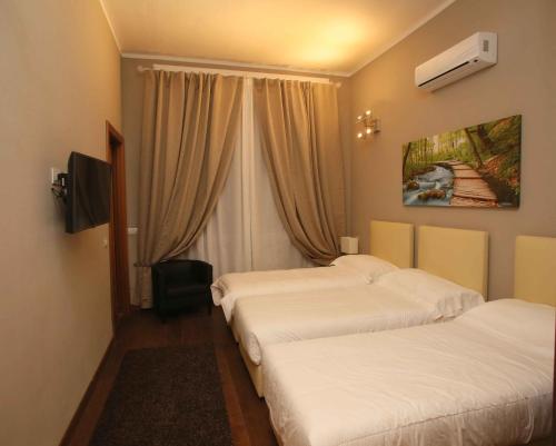 a hotel room with two beds and a window at Linate Residence in Segrate