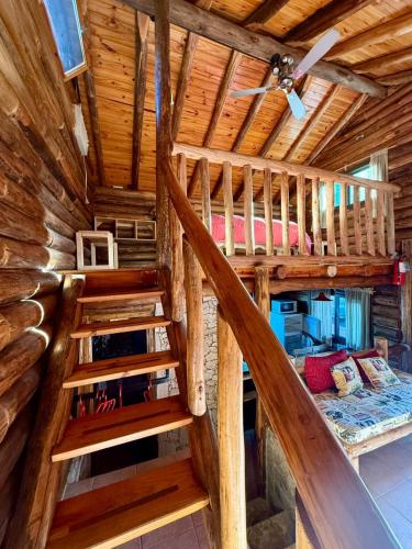 a loft bed in a log cabin with a ceiling at Cabaña Suiza in Cacheuta