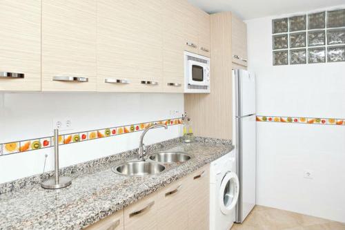 a kitchen with a sink and a white refrigerator at Casa Lenore in El Cabo de Gata