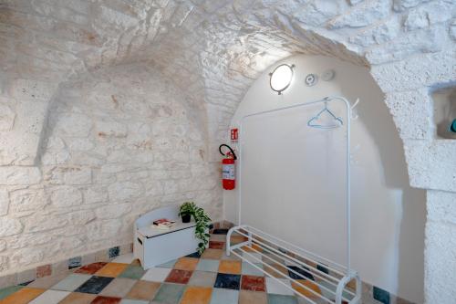 a hallway with a stone wall and a staircase at Domus Magistri in Ostuni