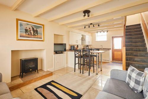 a living room with a table and a fireplace at Host & Stay - Sea Haven in Staithes