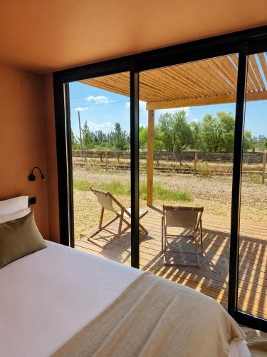 a bedroom with a bed and a view of a yard at Luz Retreat in Luz de Tavira