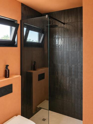 a bathroom with a glass shower with a toilet at Luz Retreat in Luz de Tavira