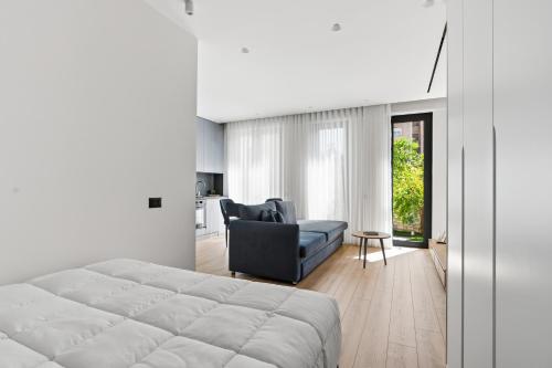 a bedroom with a bed and a couch and a chair at Le Mom Apart Hotel in Berat