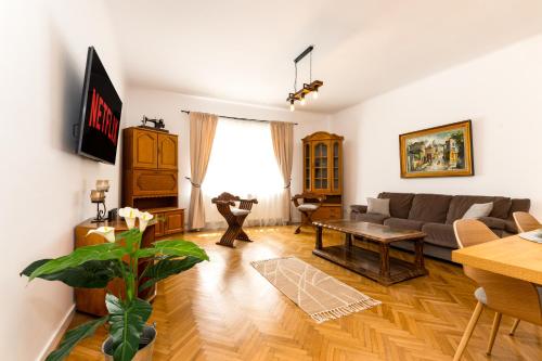 a living room with a couch and a table at The Bucket - Calla Old Town House with Jacuzzi & View in Braşov