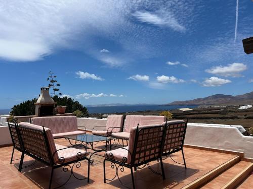 a patio with chairs and a table on a deck at Casa Tara - 5 bedroom, 4 bathroom villa with private pool in Mácher