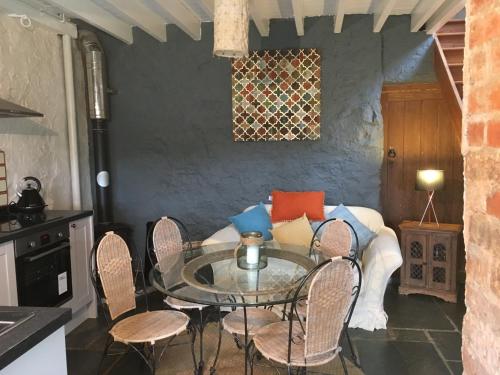 a dining room with a glass table and a couch at Cottage Sleeps 4 with Wifi in Llanfairpwllgwyngyll