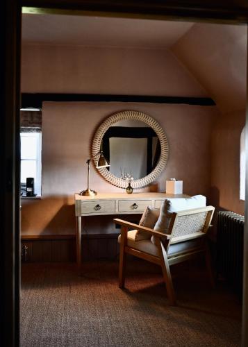 a bedroom with a mirror and a table and a chair at Botley Hill Farmhouse in Warlingham