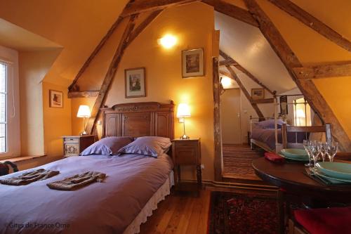 a bedroom with a large bed and a table at La Berlandière in Le Merlerault