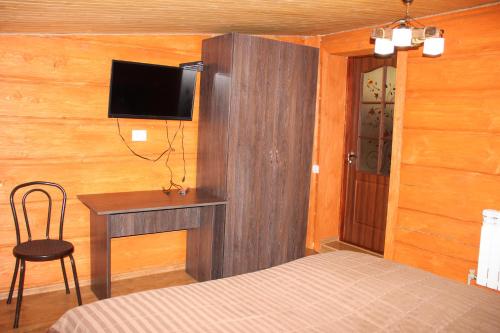 a bedroom with a bed and a desk with a television at Hotel Duet in Maydan
