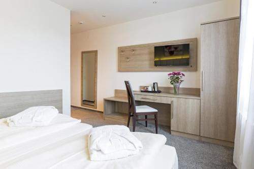 a hotel room with two beds and a desk at Bavaria Hotel Münchner Hof Superior in Stuttgart