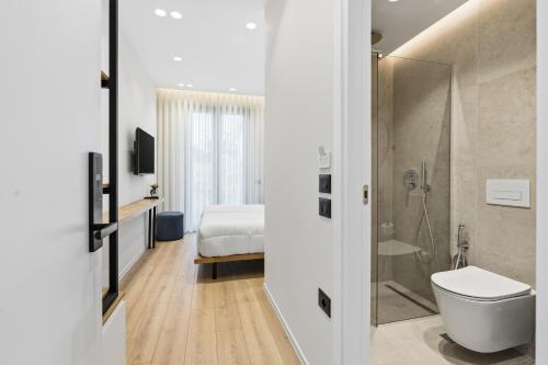 a bathroom with a shower and a toilet and a bed at Le Mom Apart Hotel in Berat