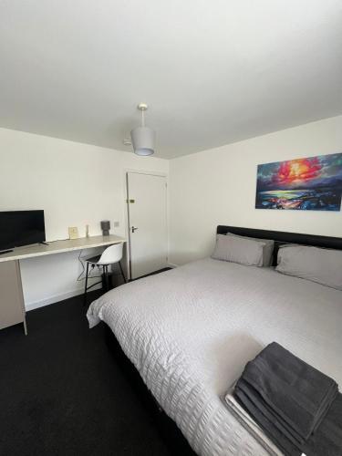 a bedroom with a bed and a desk with a computer at The M Rooms at 144 in Kirk of Shotts