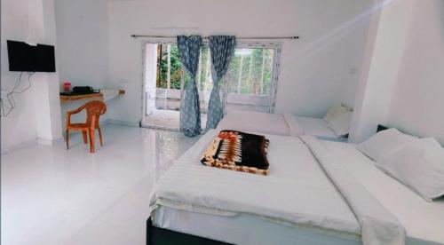 a bedroom with two beds and a table and a window at ANS Green Villa in Yercaud