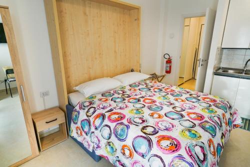 a bedroom with a large bed with a colorful comforter at Blue Iris - Varese - Laghi Svizzera in Varese