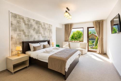 a bedroom with a bed and a large window at Vila Emerald Residence in Râşnov