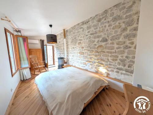 a bedroom with a stone wall and a bed at Chambres d'hotes lecortile in Villeneuve-lès-Maguelonne