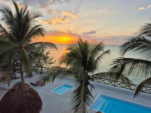 a view of a resort with a pool and palm trees at Choby's House Holbox in Holbox Island
