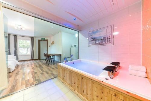a large bathroom with a tub in a room at Gapyeong Ohneulharu Spa Pension Pet friendly in Gapyeong