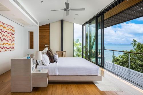 a bedroom with a bed and a large window at The View in Taling Ngam Beach