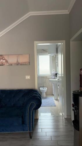 a living room with a blue couch and a bathroom at Vila 007 in Velipojë