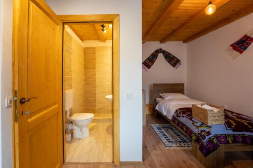a bathroom with a bed and a toilet in a room at Sieben Türen in Criţ