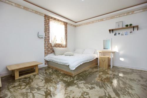 a white room with a bed and a television at Danyang paramaeul in Danyang