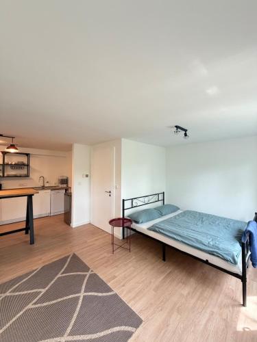a bedroom with a bed in a room with a kitchen at Apartment Am Wald in Idar-Oberstein