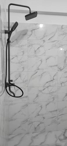 a bathroom with a shower with white marble at Garsoniera Daria in Saturn
