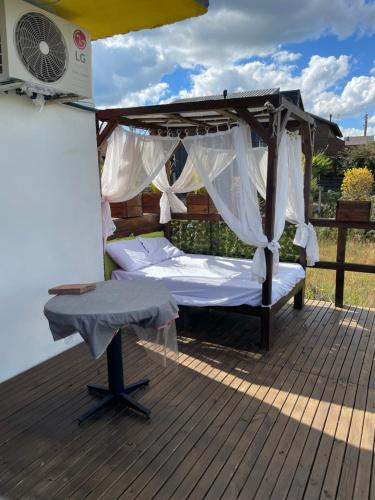 a canopy bed on a deck with a fan at Vale de cambara III in Cambará