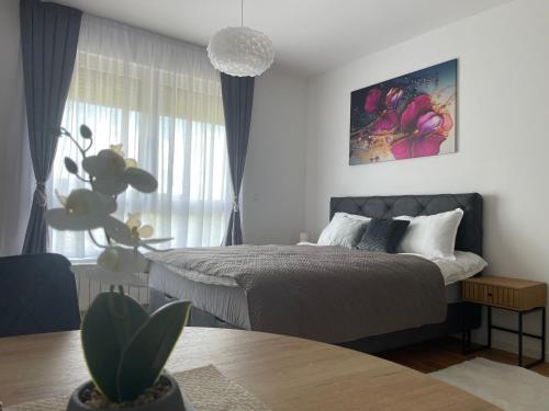 a bedroom with a bed and a potted plant at Orhideja 075 in Tuzla