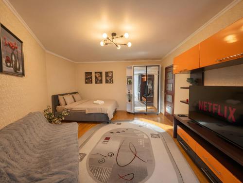a living room with a bed and a flat screen tv at RentHouse Apartments Metropolis in Chişinău