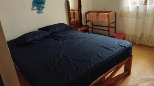 a bed with a blue comforter in a bedroom at Tropical Lodge Yala in Kirinda