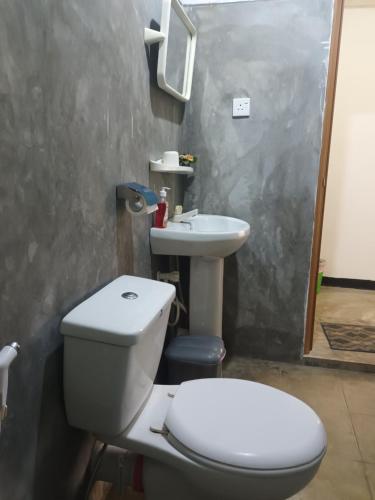 a bathroom with a toilet and a sink at Tropical Lodge Yala in Kirinda