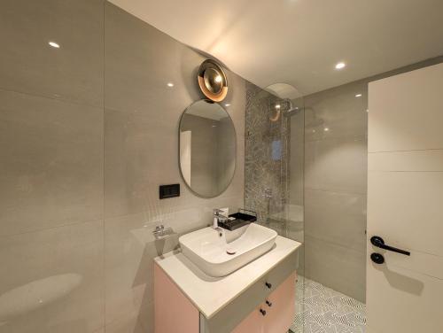 a bathroom with a sink and a mirror and a shower at Finca - the tidal nest in Candolim