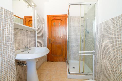 a bathroom with a sink and a shower with a glass door at Bambinopoli Al Mare in Alba Adriatica